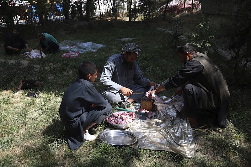 Men slaughter sheep on the first day of Eid al-Adha in Kabul, Afghanistan, Friday, July 31, 2020. During Eid al-Adha, or Feast of Sacrifice, Muslims slaughter sheep or cattle and distribute portions of the meat to the poor. (AP Photo/Rahmat Gul)