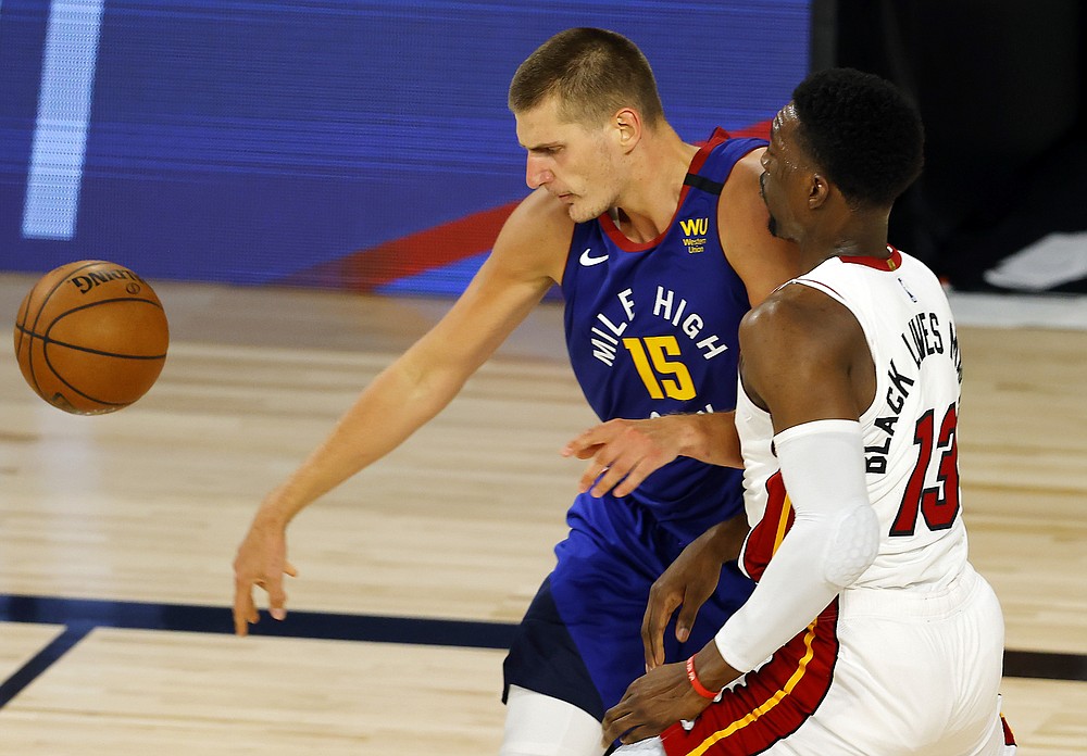 Denver Nuggets' Nikola Jokic loses control of the ball against Miami Heat's Bam Adebayo during an NBA basketball game, Saturday, Aug. 1, 2020, in Lake Buena Vista, Fla. (Kevin C. Cox/Pool Photo via AP)