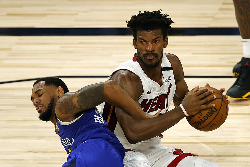 Denver Nuggets' Monte Morris tangles for the ball against Miami Heat's Jimmy Butler during an NBA basketball game, Saturday, Aug. 1, 2020, in Lake Buena Vista, Fla. (Kevin C. Cox/Pool Photo via AP)