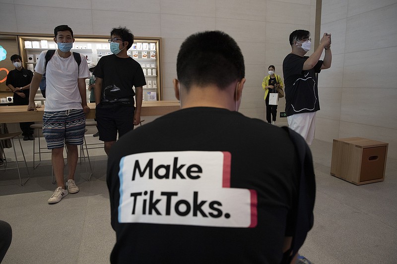 A man wearing a shirt promoting TikTok is seen at an Apple store in Beijing on Friday, July 17, 2020. U. S. President Donald Trump says he wants to take action to ban TikTok, a popular Chinese-owned video app that has been a source of national security and censorship concerns. (AP Photo/Ng Han Guan)