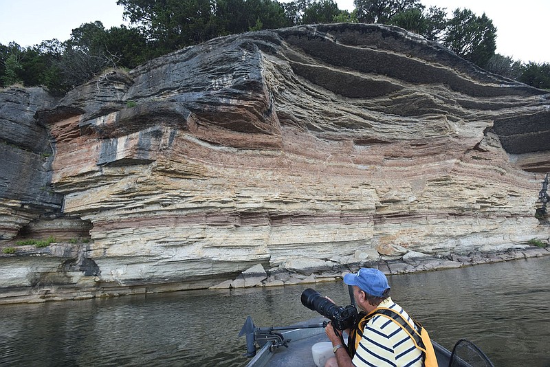 Terry Stanfill looks at cliff swallow nests along a Beaver Lake bluff north of Rocky Branch park. Hundreds of nests can be seen along bluffs near the park. Swallows can be seen, too, earlier in the year.
(NWA Democrat-Gazette/Flip Putthoff)