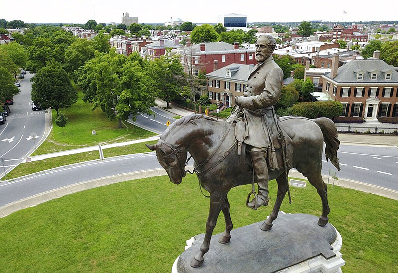 FILE - This Tuesday June 27, 2017, file photo shows the statue of Confederate General Robert E. Lee that stands in the middle of a traffic circle on Monument Avenue in Richmond, Va.  A Virginia judge on Monday, Aug. 3, 2020 dissolved one injunction but imposed another preventing Virginia's governor from removing an enormous statue of Confederate Gen. Robert E. Lee. (AP Photo/Steve Helber, File)