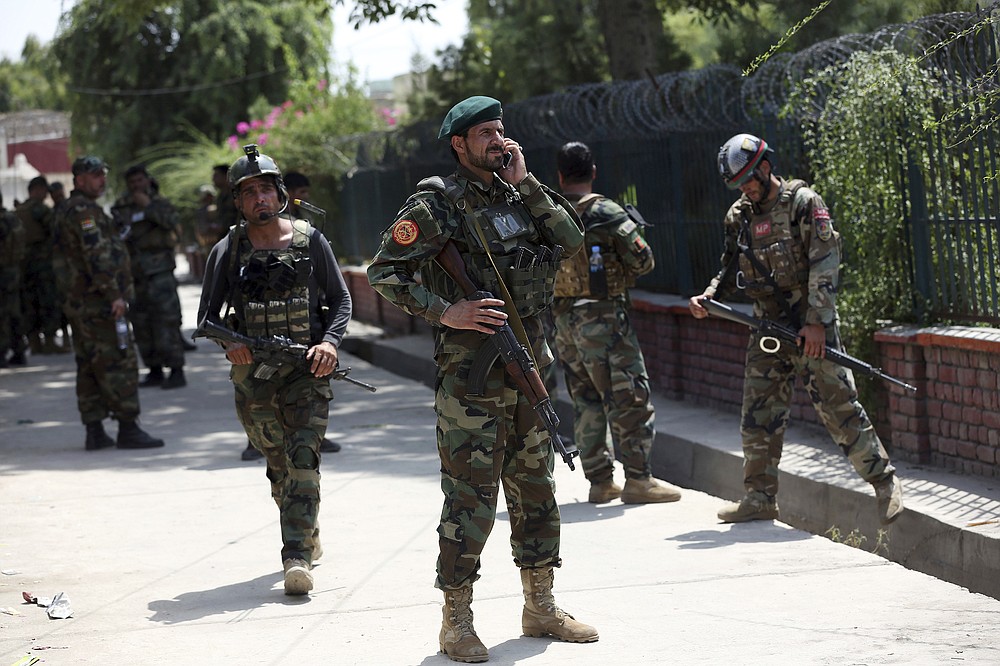 Afghan security personnel gather near a prison after an attack in the city of Jalalabad, east of Kabul, Afghanistan, Monday, Aug. 3, 2020. An Islamic State group attack on the prison in eastern Afghanistan holding hundreds of its members raged on Monday after killing people in fighting overnight, a local official said. (AP Photo/Rahmat Gul)