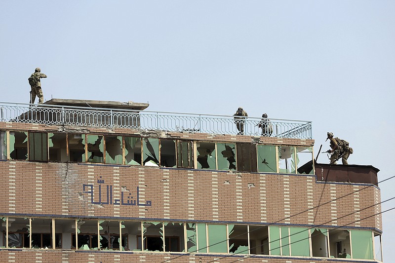 Afghan security personnel take position on the top of a building where insurgents were hiding, in the city of Jalalabad, east of Kabul, Afghanistan, Monday, Aug. 3, 2020. An Islamic State group attack on a prison in eastern Afghanistan holding hundreds of its members raged on Monday after killing people in fighting overnight, a local official said. (AP Photo/Rahmat Gul)
