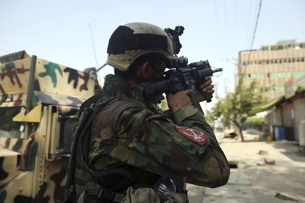 An Afghan security person takes position in front of a prison after an attack in the city of Jalalabad, east of Kabul, Afghanistan, Monday, Aug. 3, 2020. An Islamic State group attack on the prison in eastern Afghanistan holding hundreds of its members raged on Monday after killing people in fighting overnight, a local official said. (AP Photo/Rahmat Gul)