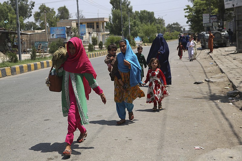 Afghan family leave their houses after an attack on a prison in the city of Jalalabad, east of Kabul, Afghanistan, Monday, Aug. 3, 2020. An Islamic State group attack on a prison in eastern Afghanistan holding hundreds of its members raged on Monday after killing people in fighting overnight, a local official said. (AP Photo/Rahmat Gul)