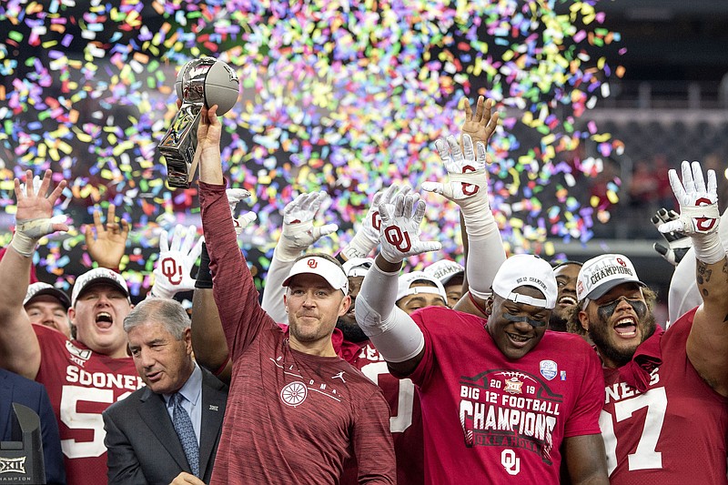 FILE - In this Dec. 7, 2019, file photo, Oklahoma head coach Lincoln Riley hosts the Big 12 Conference championship trophy after defeating Baylor 30-23 in overtime in an NCAA college football game in Arlington, Texas. Riley will earn an average of more than $7.5 million a year under a contract extension through the 2025 season. The university's board of regents approved the two-year extension Tuesday, July 28, 2020. (AP Photo/Jeffrey McWhorter, File)