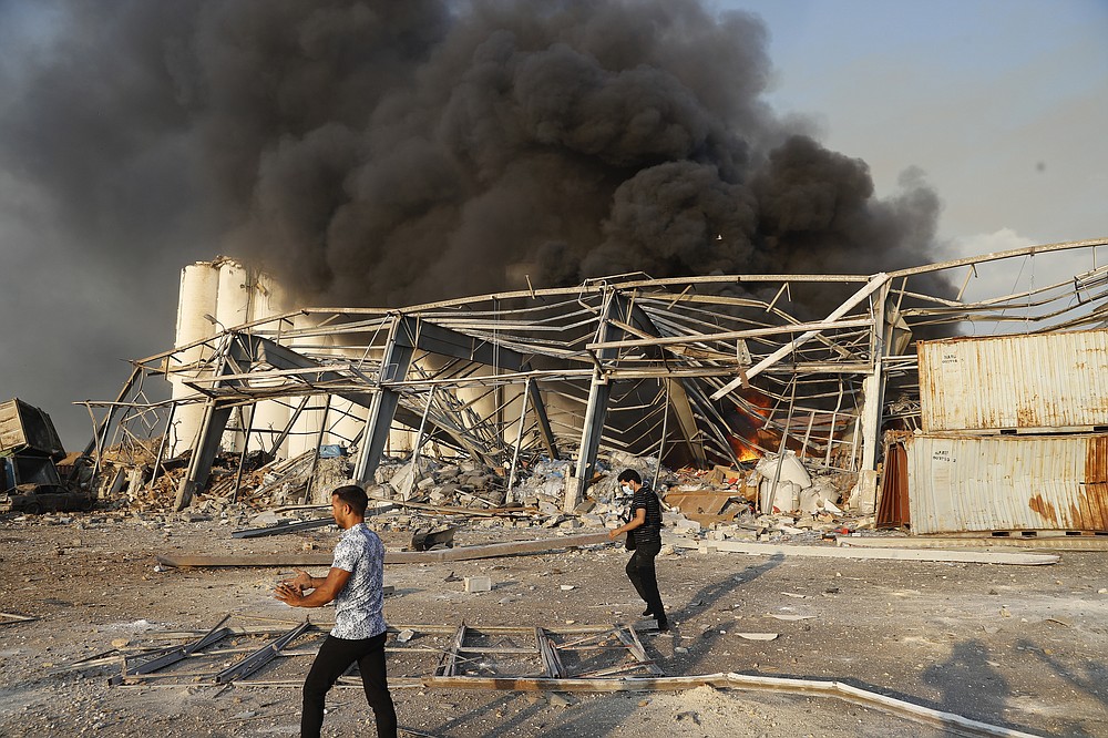 Lebanese security officers arrive at the scene of an explosion that hit the seaport of Beirut, Lebanon, Tuesday, Aug. 4, 2020. Massive explosions rocked downtown Beirut on Tuesday, flattening much of the port, damaging buildings and blowing out windows and doors as a giant mushroom cloud rose above the capital. (AP Photo/Hussein Malla)