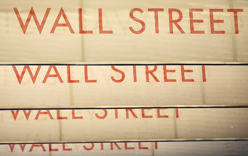 FILE - Signs for Wall Street are shown, Thursday, July 30, 2020, in New York.  Stocks are off to a weak start on Wall Street, Tuesday, Aug. 4  as investors keep a close eye on talks in Congress over the next installment of badly needed relief for people whose livelihoods and businesses were impacted by coronavirus lockdowns. (AP Photo/Mark Lennihan)