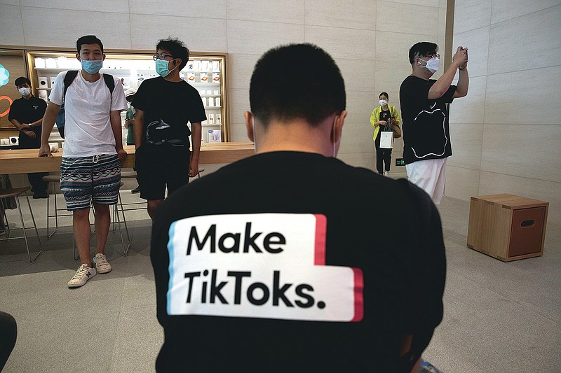 A man wearing a shirt promoting TikTok is seen at an Apple store in Beijing on Friday, July 17, 2020. U. S. President Donald Trump says he wants to take action to ban TikTok, a popular Chinese-owned video app that has been a source of national security and censorship concerns. (AP Photo/Ng Han Guan)