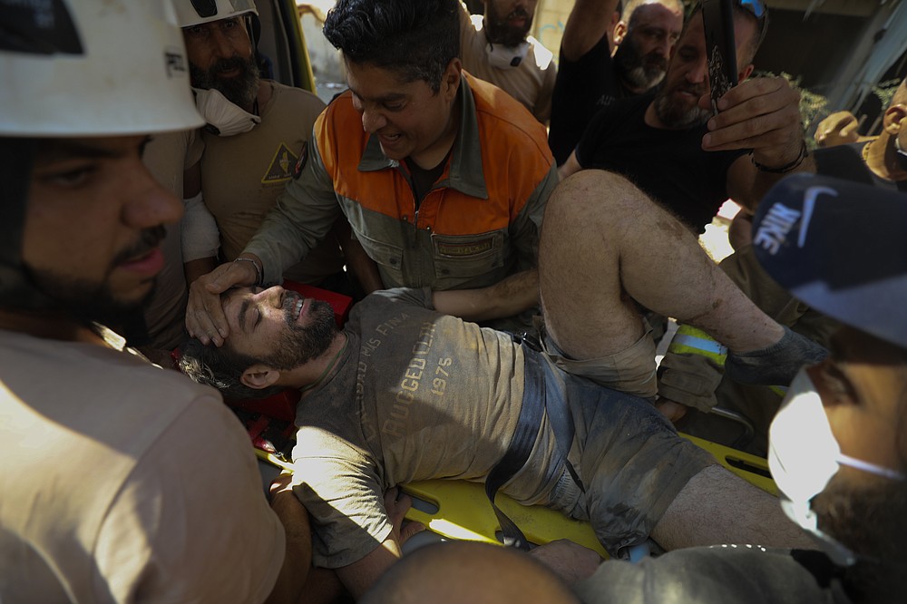 A survivor is taken out of the rubble after a massive explosion in Beirut, Lebanon, Wednesday, Aug. 5, 2020. The explosion on Tuesday flattened much of a port and damaged buildings across Beirut, sending a giant mushroom cloud into the sky. In addition to those who died, more than 3,000 other people were injured, with bodies buried in the rubble, officials said.(AP Photo/Hassan Ammar)
