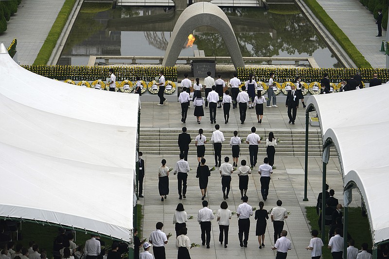 The family of the deceased offer flowers to Hiroshima Memorial Cenotaph during the ceremony to mark the 75th anniversary of the bombing at the Hiroshima Peace Memorial Park Thursday in Hiroshima, western Japan. - AP Photo/Eugene Hoshiko