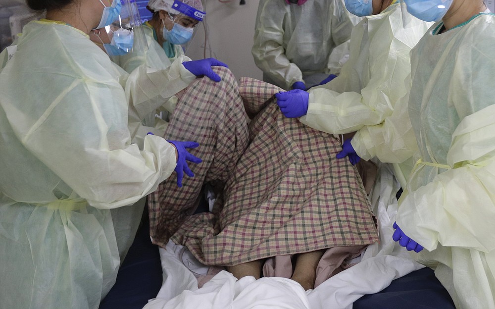 Medical personnel work with a COVID-19 patient at DHR Health, Wednesday, July 29, 2020, in McAllen, Texas. At DHR Health, the largest hospital on the border, roughly half of the 500 beds belong to coronavirus patients isolated in two units. A third unit is in the works. (AP Photo/Eric Gay)