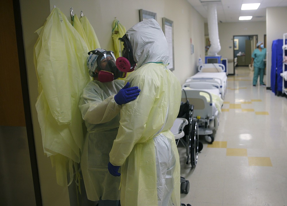 Medical personnel talk as they care for COVID-19 patients at DHR Health, Wednesday, July 29, 2020, in McAllen, Texas. (AP Photo/Eric Gay)