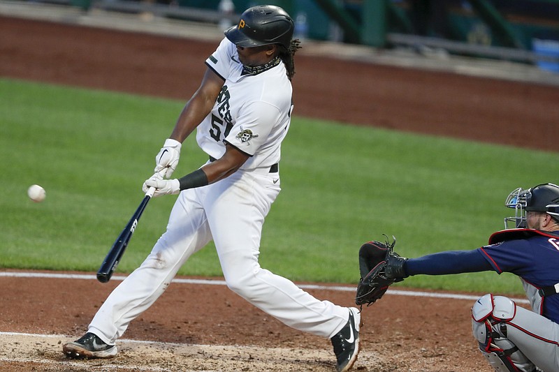 Pittsburgh Pirates' Josh Bell, left, hits a double in front of Minnesota Twins catcher Mitch Garver in the fourth inning of a baseball game, Wednesday, Aug. 5, 2020, in Pittsburgh. (AP Photo/Keith Srakocic)