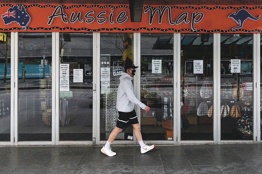 A man walks past a shop closed down store selling Australian paraphernalia items aimed at International tourists during lockdown in Melbourne, Australia, Wednesday, Aug. 5, 2020. Victoria state, Australia's coronavirus hot spot, announced on Monday that businesses will be closed and scaled down in a bid to curb the spread of the virus. (AP Photo/Asanka Brendon Ratnayake)