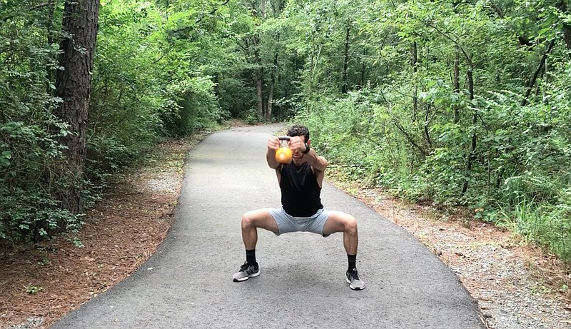 Eric Godwin does the Wide/Narrow Squat Raise on a trail near Little Rock Athletic Club. (Democrat-Gazette photo illustration/Celia Storey)