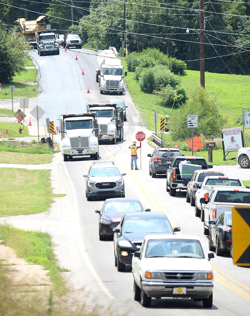 Westside Eagle Observer/MIKE ECKELS

While southbound traffic is held by a flagger, northbound motorist move pass the paving equipment Aug. 6 during the Arkansas 59 paving project in Decatur.