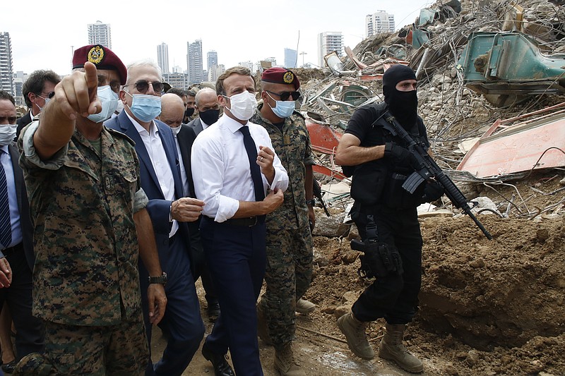 French President Emmanuel Macron, center, visits the devastated site of the explosion at the port of Beirut, Lebanon, Thursday. French President Emmanuel Macron has arrived in Beirut to offer French support to Lebanon after the deadly port blast. - AP Photo/Thibault Camus