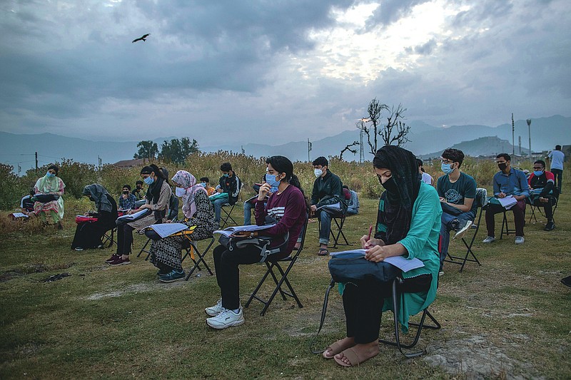 Kashmiri students attend an open-air early morning class inside Eidgah, a ground reserved for Eid prayers, in Srinagar, Indian controlled Kashmir, Friday, July 18, 2020. When months went by without teaching, Muneer Alam, an engineer-turned-math teacher, started the informal community school in the form of an open-air classroom in June. Schools in the disputed region reopened after six months in late February, after a strict lockdown that began in August 2019, when India scrapped the region’s semi-autonomous status. In March schools were shut again because of the coronavirus pandemic. (AP Photo/Dar Yasin)