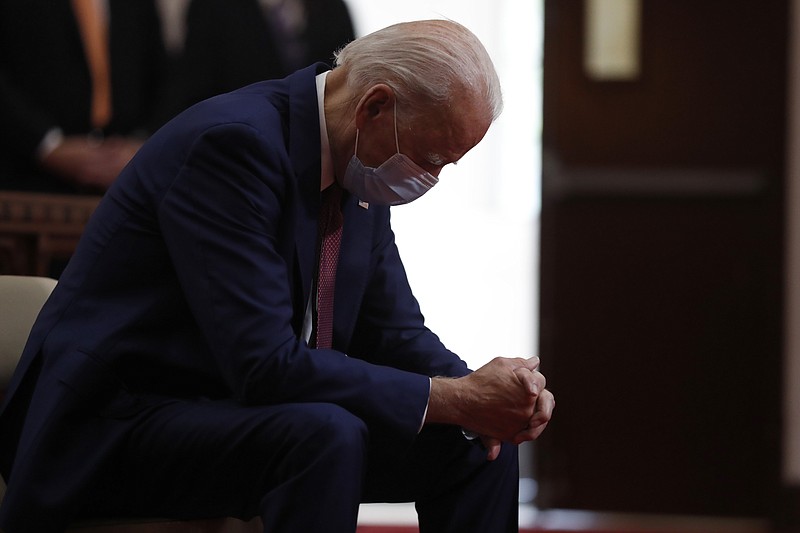 FILE - In this  June 1, 2020, file photo, Democratic presidential candidate, former Vice President Joe Biden bows his head in prayer as he visits Bethel AME Church in Wilmington, Del. Photos in a campaign ad for President Donald Trump show that former Vice President Biden is “alone, hiding, diminished.” The ad blurs details that show Biden is praying in a church.  The ad was tweeted by @TeamTrump on Wednesday, Aug. 5, 2020. (AP Photo/Andrew Harnik, File)