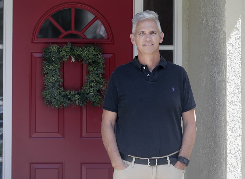Bob Garick stands by the entrance to his home Wednesday, Aug. 5, 2020, in Oviedo, Fla. Garick was looking forward to being a field supervisor during the door-knocking phase of the 2020 census, but as the number of new coronavirus cases in Florida shot up last month, he changed his mind and decided not to take the job. The loss of these so-called door-knockers - formally known as enumerators - is happening just when the agency faces newly tightened deadlines to reach the hardest to count communities, including minorities and immigrants. (AP Photo/John Raoux)