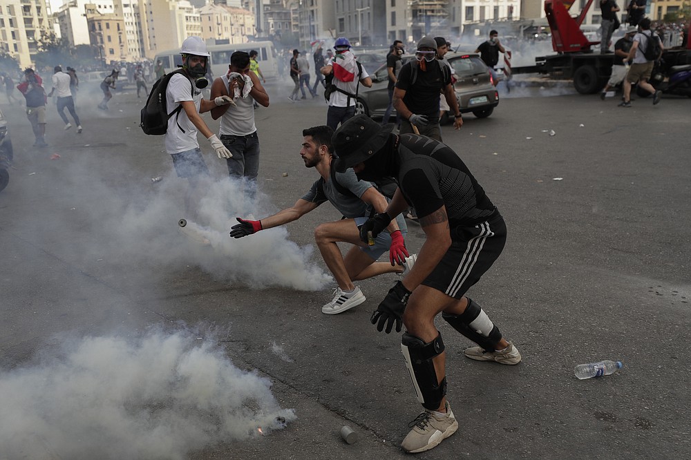 People clash with police during a protest against the political elites and the government after this week's deadly explosion at Beirut port which devastated large parts of the capital and killed more than 150 people, in Beirut, Lebanon, Saturday, Aug. 8, 2020. (AP Photo/Hassan Ammar)