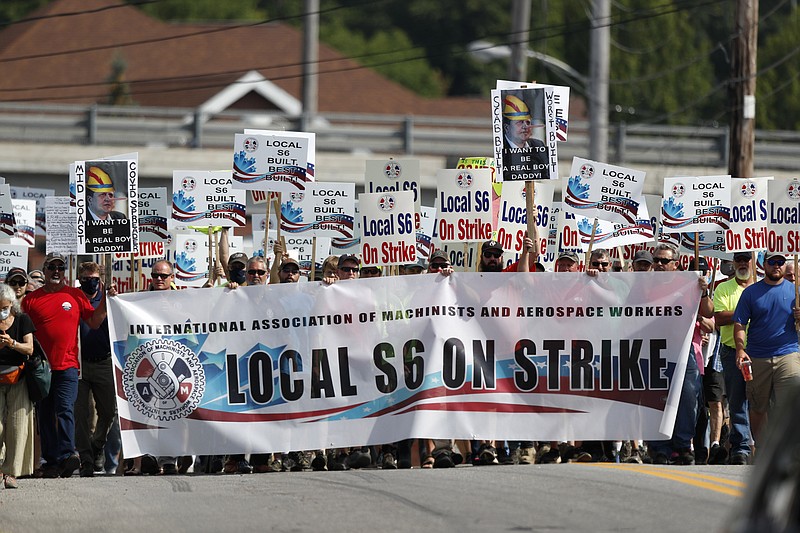 FILE - Striking Bath Iron Works shipbuilders march in solidarity, Saturday, July 25, 2020, in Bath, Maine.  The union representing striking production workers says a tentative agreement was reached with Navy shipbuilder Bath Iron Works to end a strike that stretched for more than a month during a global pandemic. The agreement announced on Saturday, Aug. 8,  will be put forth to the 4,300 members of Machinists Local S6 for approval. (AP Photo/Robert F. Bukaty, File)