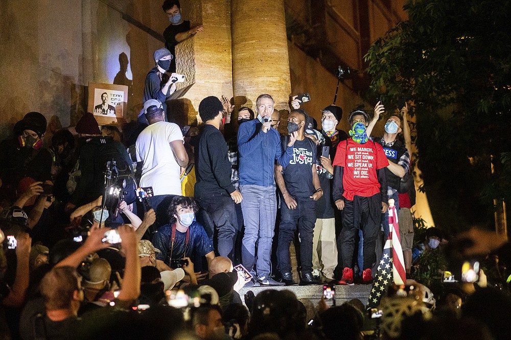 FILE - In this July 22, 2020, file photo, Mayor Ted Wheeler speaks to Black Lives Matter protesters in Portland, Ore. Protests in Portland have topped the headlines for days, but lost in the shouting are the voices of Black Portlanders themselves and their feelings about the unrest are nuanced and diverse. (AP Photo/Noah Berger, File)