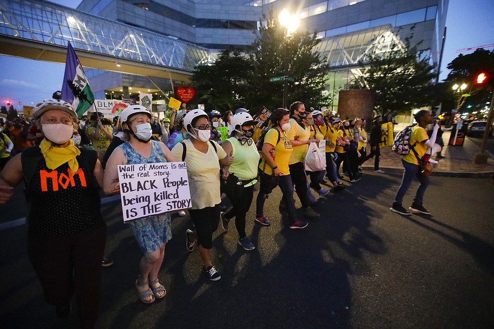 FILE - In this July 29, 2020, file photo, members of the "Wall of Moms" protest group march during a Black Lives Matter protest in Portland, Ore. Protests in Portland have topped the headlines for days, but lost in the shouting are the voices of Black Portlanders themselves and their feelings about the unrest are nuanced and diverse. (AP Photo/Marcio Jose Sanchez, File)