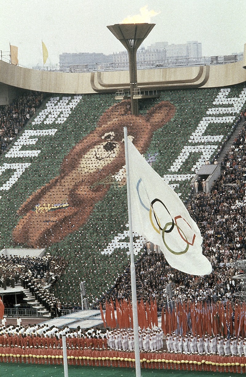 Members of the crowd hold up 3,500 cards to create an image of Misha the Bear Cup, the mascot of the Moscow Olympic Games, at the Lenin Stadium in Russia on July 19, 1980. Above burns the Olympic flame. - The Associated Press file photo