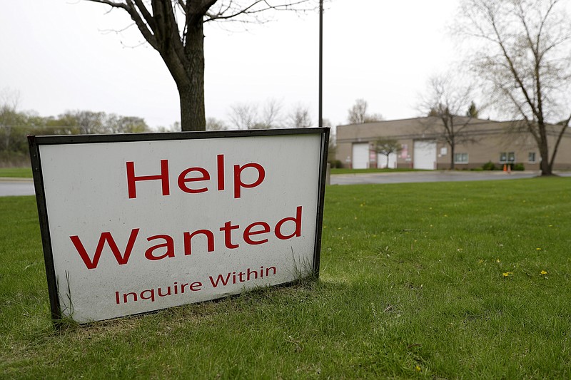 FILE - In this May 5, 2020 file photo, a help wanted sign shows at Illinois Air Team Test Station in Lincolnshire, Ill. U.S. employers advertised more jobs in June 2020 compared with May, but overall hiring fell, painting a mixed picture of the job market. The number of jobs posted on the last day in June jumped 9.6% to 5.9 million, the Labor Department said Monday, Aug. 10 a solid gain but still below the pre-pandemic level of about 7 million.   (AP Photo/Nam Y. Huh)