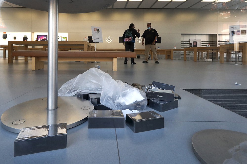 Apple iPhone boxes lay on the floor, Monday, Aug. 10, 2020, inside an Apple Store that was vandalized overnight in the Lincoln Park neighborhood in Chicago. Chicago’s police commissioner says more than 100 people were arrested following a night of looting and unrest that left several officers injured and caused damage in the city’s upscale Magnificent Mile shopping district and other parts of the city. (AP Photo/Charles Rex Arbogast)