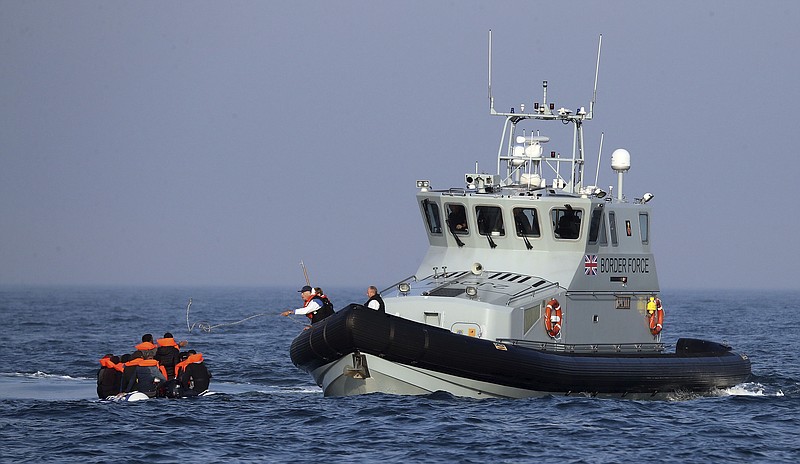 A Border Force vessel assist a group of people thought to be migrants on board from their inflatable dinghy in the Channel, Monday Aug. 10, 2020. A Royal Air Force surveillance plane is flying over the English Channel as the British government tries to curb the number of people crossing from France in small boats. Britain’s Conservative government has talked tough amid a surge in the number of migrants crossing the Channel during recent warm summer weather. (Gareth Fuller/PA via AP)
