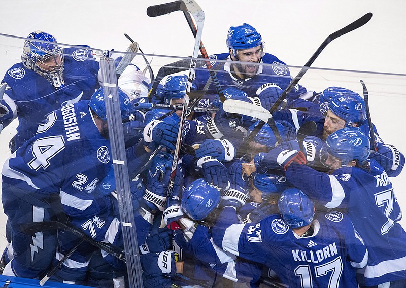 The Tampa Bay Lightning celebrate after Brayden Point (21) scored against the Columbus Blue Jackets during the fifth overtime in Game 1 of Tuesday's NHL Stanley Cup first-round playoff series in Toronto. - Photo by Frank Gunn/The Canadian Press via The Associated Press