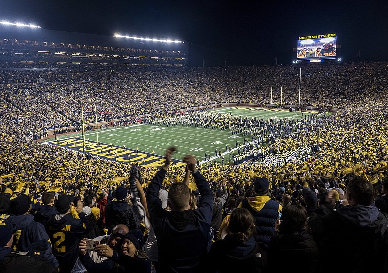 Fans cheer as the Michigan team takes the field at Michigan Stadium for an Oct. 13, 2018, NCAA football game against Wisconsin in Ann Arbor, Mich. Michigan's Big House will be sitting empty when the leaves start to change this fall. From Ann Arbor to Los Angeles to Oxford, that most American of pursuits, college football, has either given up hope of getting in a traditional season or is flinging what amounts to a Hail Mary pass in a desperate attempt to hang on in the age of COVID-19. - Photo by Tony Ding of The Associated Press