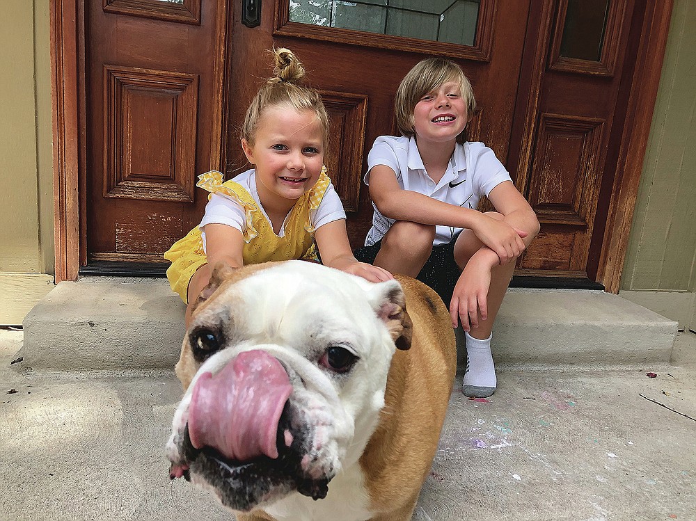 This image released by Jennifer Asbury shows her kids, Luca Asbury, 6, left, and her brother Will Asbury, 8, with their dog Drake in Littleton, Colo. Will Asbury is going into third grade. School starts Aug. 24 and he'll be there in person. There was a distance learning option but Will and his little sister, Luca, wanted to go. (Jennifer Asbury via AP)