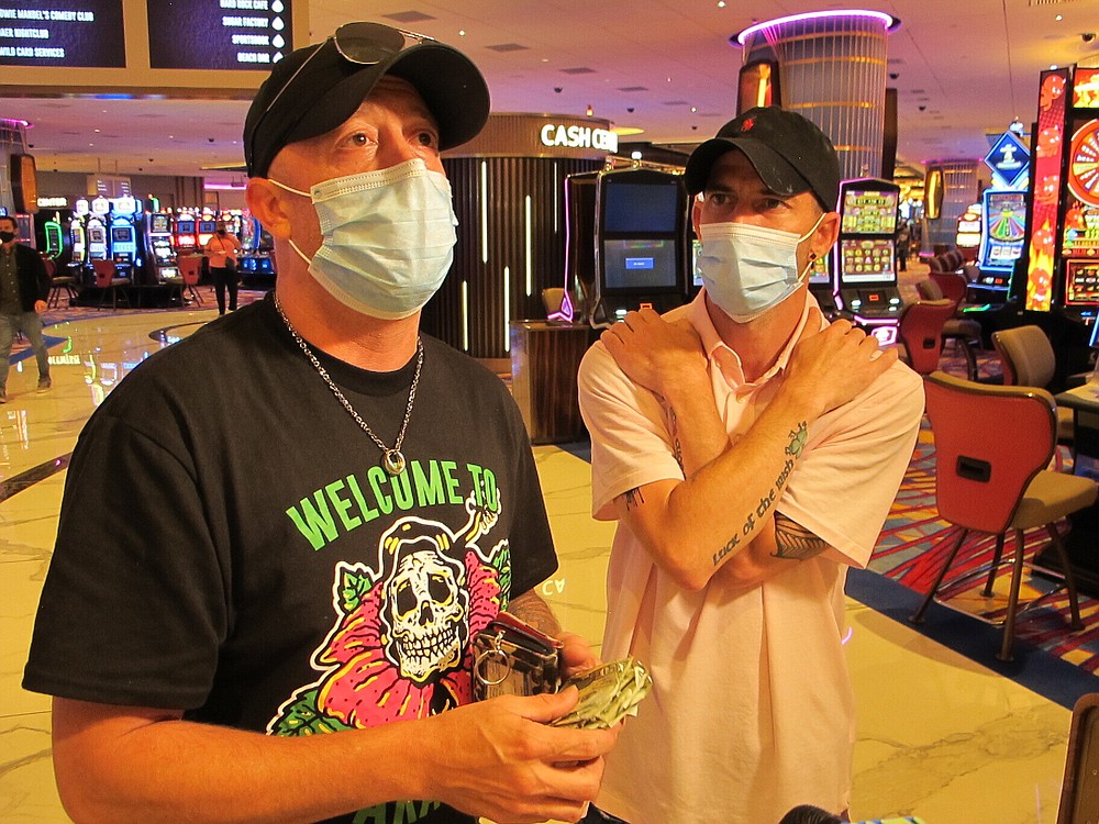 Mike McLaughlin, kiri, memperlihatkan segumpal uang tunai yang ia dan temannya Johnny Solis, kanan, berencana berjudi di kasino Hard Rock di Atlantic City N.J. pada 2 Juli 2020, hari kasino dibuka kembali di tengah wabah virus corona. Kasino dan trek kuda New Jersey memenangkan $ 264,5 juta pada bulan Juli, angka yang turun hampir 21% dari tahun lalu, tetapi rumah judi dengan senang hati akan mengambil setelah berbulan-bulan tidak aktif. (Foto AP / Wayne Parry)