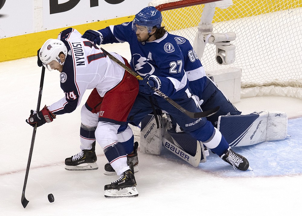 Columbus Blue Jackets center Gustav Nyquist (14) tries to pass the puck as Tampa Bay Lightning defenseman Ryan McDonagh (27) clears him out of the crease in front of Lightning goaltender Andrei Vasilevskiy (88) during second-period of NHL Eastern Conference Stanley Cup first round playoff hockey game action in Toronto, Thursday, Aug. 13, 2020. (Frank Gunn/The Canadian Press via AP)