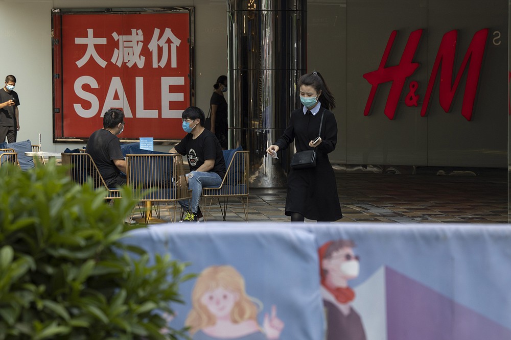 Shoppers wearing mask to curb the spread of the coronavirus visit a retail district in Beijing on July 22, 2020. China's factory output rose just under 5% last month from a year earlier while retail sales fell slightly, suggesting the country's recovery from the coronavirus pandemic remains muted. (AP Photo/Ng Han Guan)