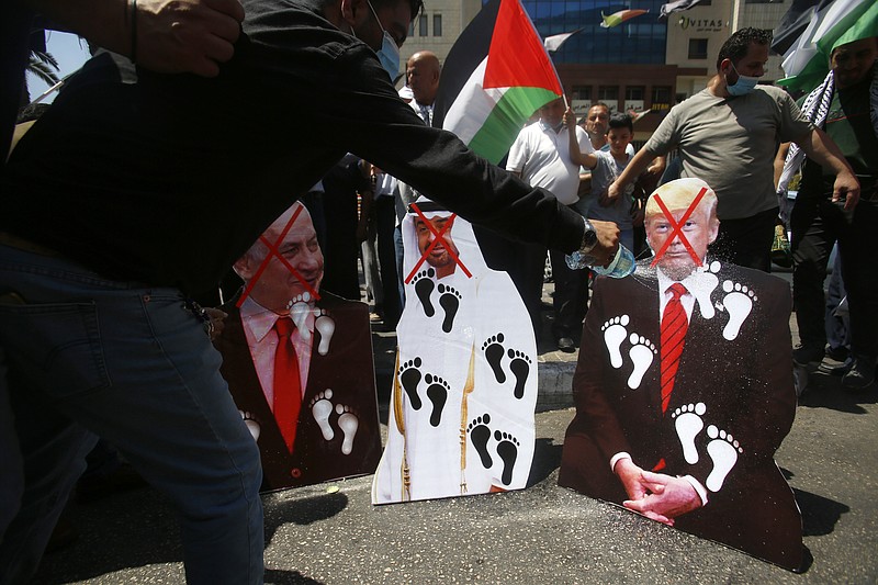 Palestinians burn pictures of U.S. President Donald Trump, Abu Dhabi Crown Prince Mohammed bin Zayed al-Nahyan and and Israeli Prime Minister Benjamin Netanyahu during a protest against the United Arab Emirates' deal with Israel, in the West Bank city of Nablus, Friday, Aug. 14, 2020.(AP Photo/Majdi Mohammed)