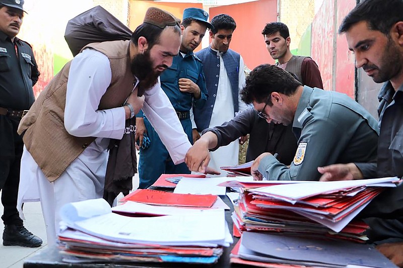 Taliban prisoners are checked with documents as they are released from Pul-e-Charkhi jail in Kabul, Afghanistan, Thursday, Aug. 13, 2020. Afghanistan released the first 80 of a final 400 Taliban prisoners, paving the way for negotiations between the warring sides in Afghanistan’s protracted conflict, the government said Friday, Aug. 14, 2020. (Afghanistan's National Security Council via AP)