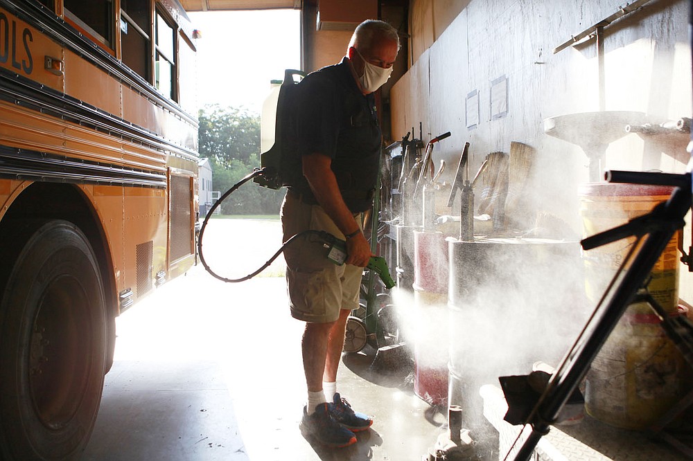 Tim Martin, who oversees the company Ecovasive's work in Arkansas, applies the company's antiviral spray to Hope Public School's transportation facility on Aug. 4. Martin said the spray prevents viruses and other microbes from sticking to surfaces. The treatment is one of many extra steps school districts around the state are taking to try to prevent the spread of coronavirus.