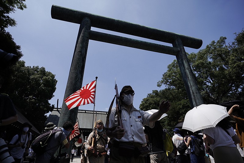 Visitors in Japanese Imperial army and navy uniforms walk near Yasukuni Shrine, which honors Japan's war dead, Saturday, Aug. 15, 2020, in Tokyo. Japan marked the 75th anniversary of the end of World War II. (AP Photo/Eugene Hoshiko)