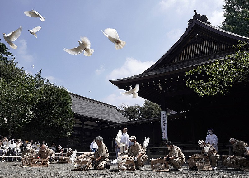 Employees release doves, wishing for the world's peace and paying respects to the war dead at Yasukuni Shrine Saturday, Aug. 15, 2020, in Tokyo. Japan marked the 75th anniversary of the end of World War II. (AP Photo/Eugene Hoshiko)