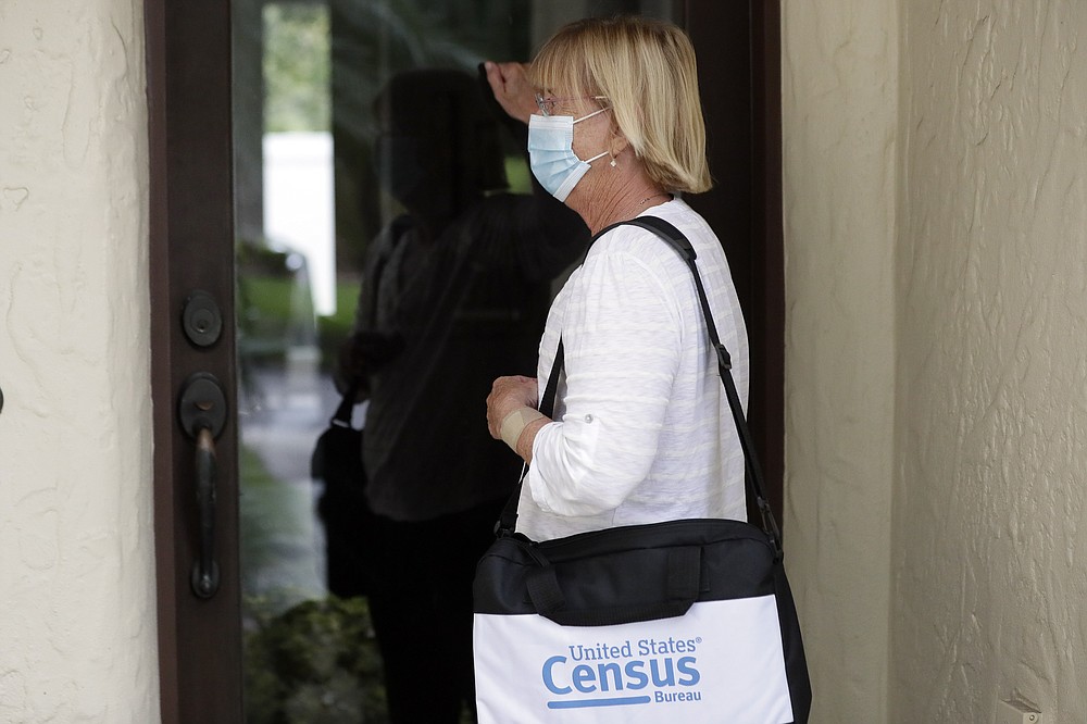 A census taker knocks on the door of a residence Tuesday, Aug. 11, 2020, in Winter Park, Fla. A half-million census takers head out en mass this week to knock on the doors of households that haven't yet responded to the 2020 census. (AP Photo/John Raoux)