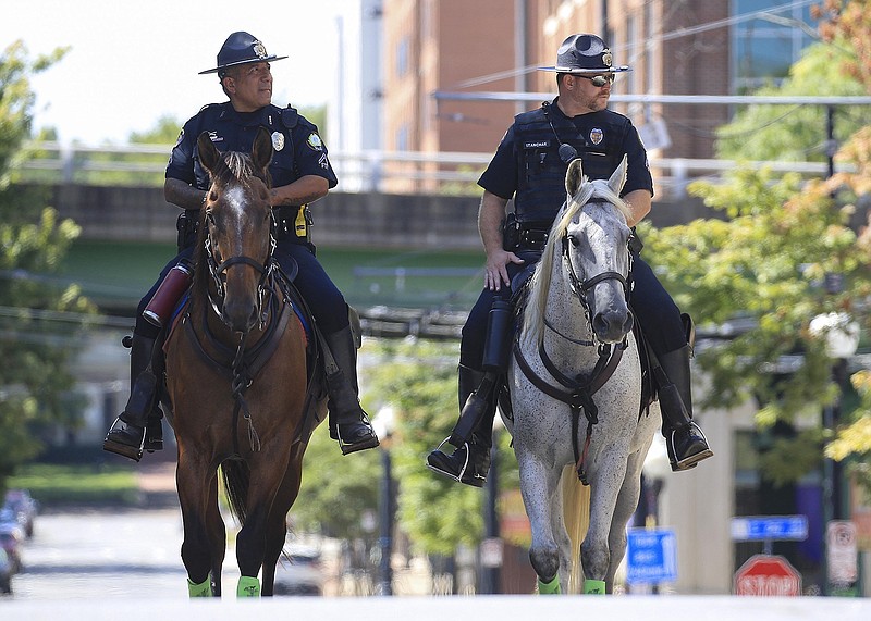 Little Rock Police officers Vincent Lucio, left, on Punch and Jimmy Stanchak on Chip ride through the River Market area Monday Aug. 17, 2020 in Little Rock.(Arkansas Democrat-Gazette/Staton Breidenthal)