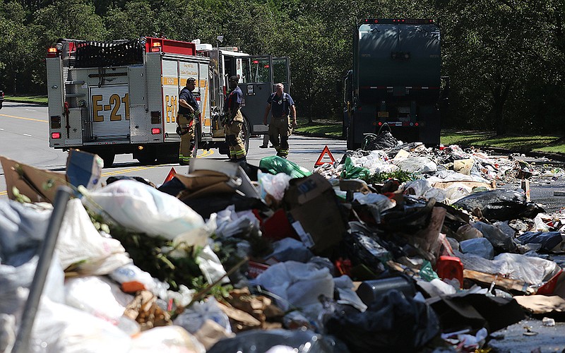 Little Rock Firefighters clean up after putting out a trash fire from a garbage truck which had its load catch fire on Monday, Aug. 17, 2020, on Chenonceau Blvd. in west Little Rock. The fire was quickly extinguished and no injuries were reported. 
(Arkansas Democrat-Gazette/Thomas Metthe)
