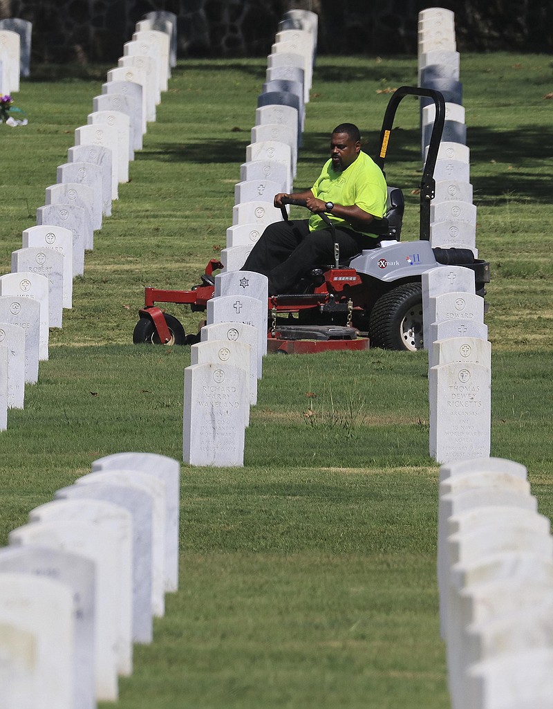Groundskeeper Calvin Davis works Monday Aug. 17, 2020 in Little Rock mowing grass at the Little Rock National Cemetery.(Arkansas Democrat-Gazette/Staton Breidenthal)