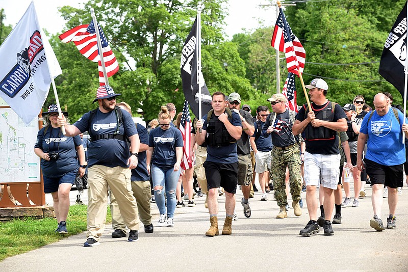 WALK REMEMBERS VETERANS
Sheep Dog Impact Assistance members, including Michael Nimmo (center), begin the Carry the Load walk on Saturday May 23 2020 at Lake Bella Vista to remember fallen veterans over Memorial day and every day of the year. Carry the Load is a national effort to bring all Amercans and veterans groups together to honor veterans each day. Sheep Dog Impact Assistance members normally place flags on the graves of veterans at the Fayetteville National Cemetery, but the U.S. Department of Veterans Affairs has ordered that no flag placements or public ceremonies are to be held at any national cemetery over Memorial Day weekend this year. The walk was an alternative remembrance, said Kay Ricker with Sheep Dog Impact Assistance. The group has chapters in several states, Ricker said. Many of the 50 or so walkers carried flags and wore backpacks emblazoned with the names of veterans. The walk began at the Veterans Wall of Honor at Lake Bella Vista. Walkers visited the memorial during the event. Go to nwaonline.com/200524Daily/ to see more photos.
(NWA Democrat-Gazette/Flip Putthoff)
